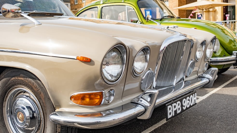  Close up of the bonnet, headlights, grille and bumper of a classic Jaguar car